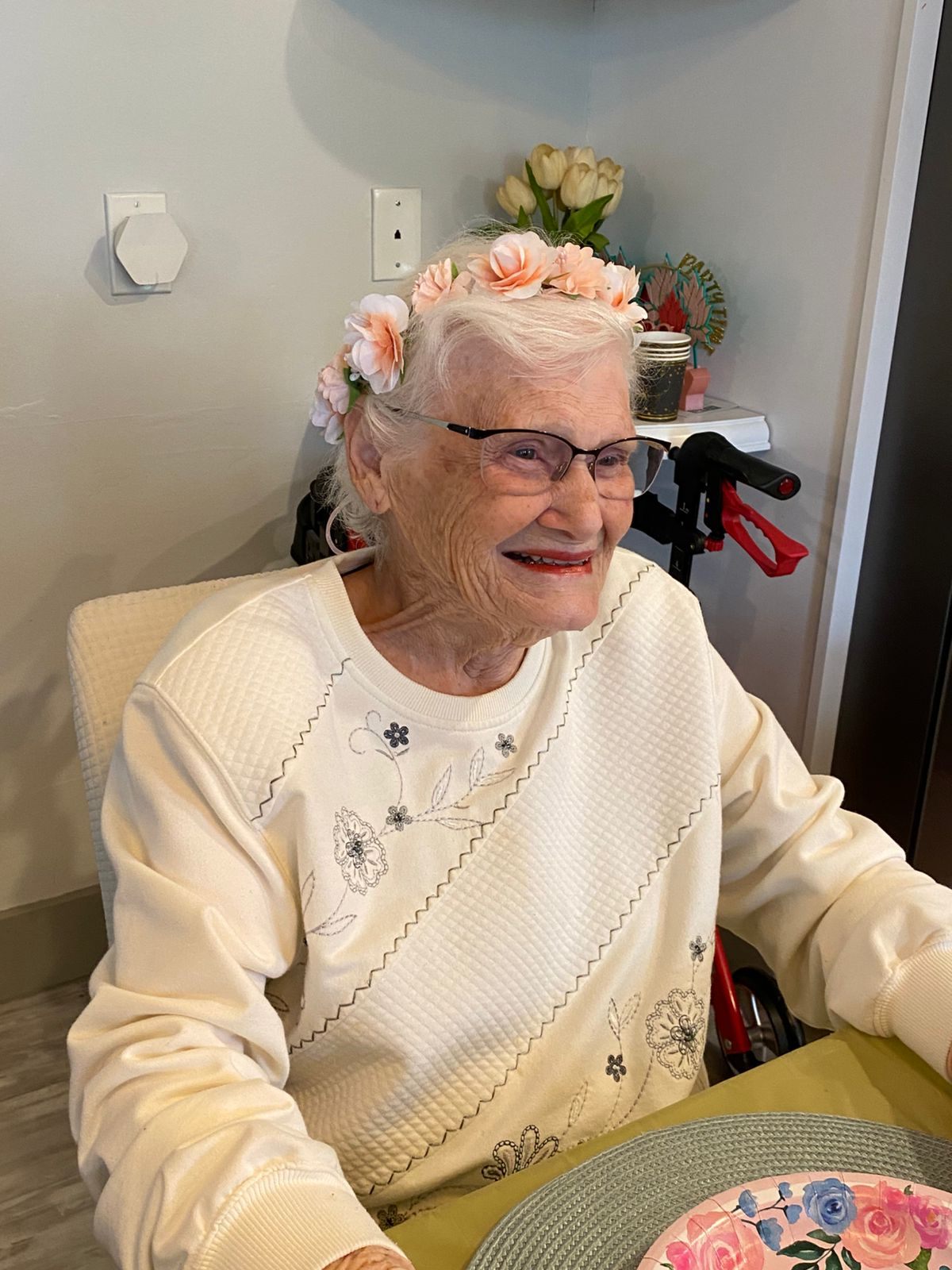 A resident wearing a flower crown and smiling at a party
