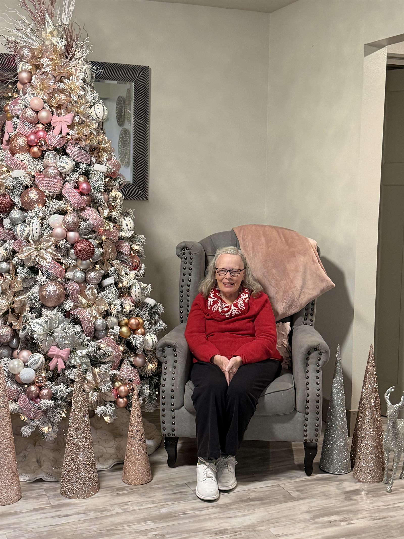 A resident sitting beside the decorated Christmas tree