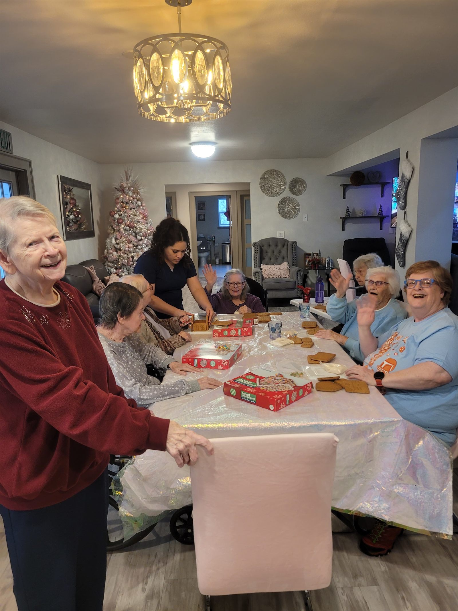 Residents and a caregiver building gingerbread houses together