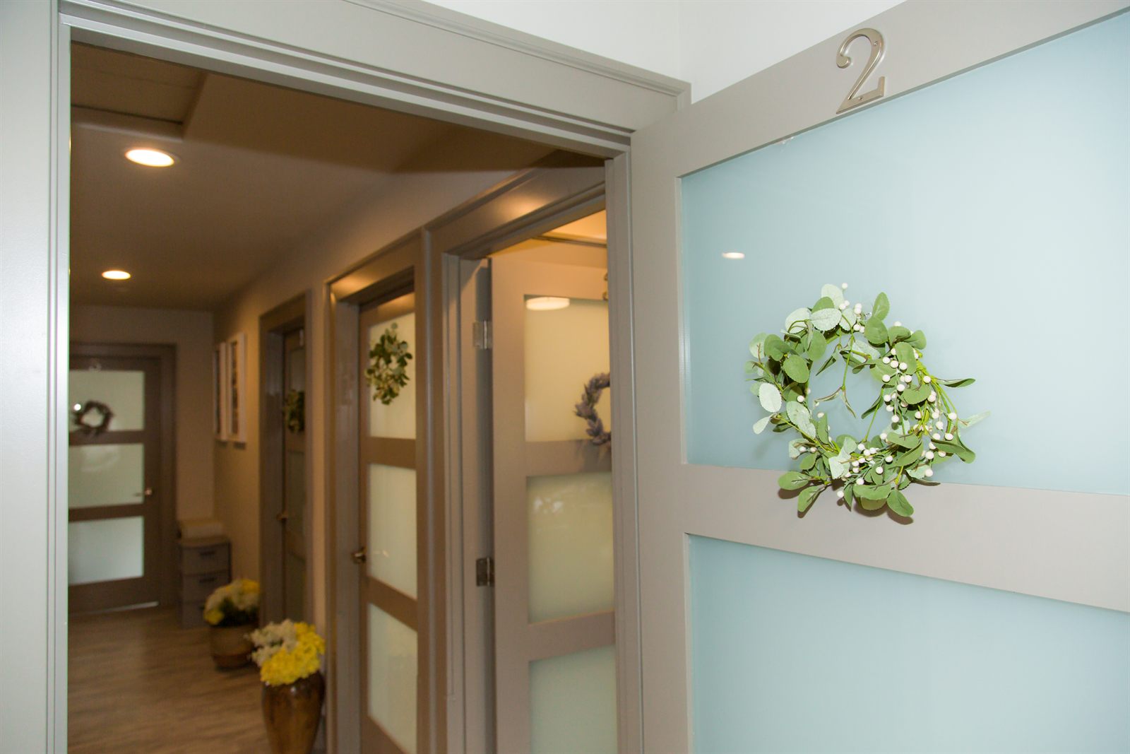 Bedroom hallway with numbered doors and seasonal wreaths